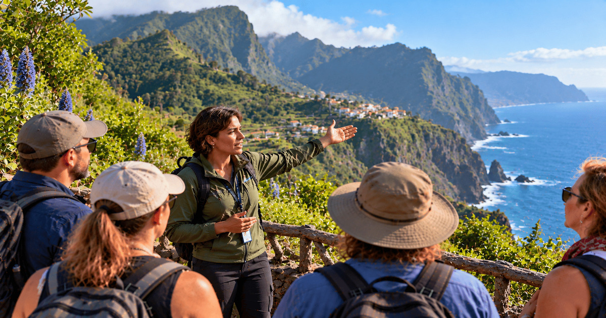 Guide touristique présentant les magnifiques montagnes côtières de Madère à un groupe de randonneurs, avec une vue panoramique sur les falaises verdoyantes, les villages pittoresques et les eaux bleues de l'océan Atlantique.