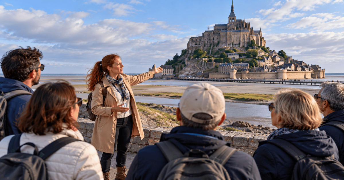 Guide touristique présentant le Mont-Saint-Michel à un groupe de visiteurs face à l'abbaye historique.