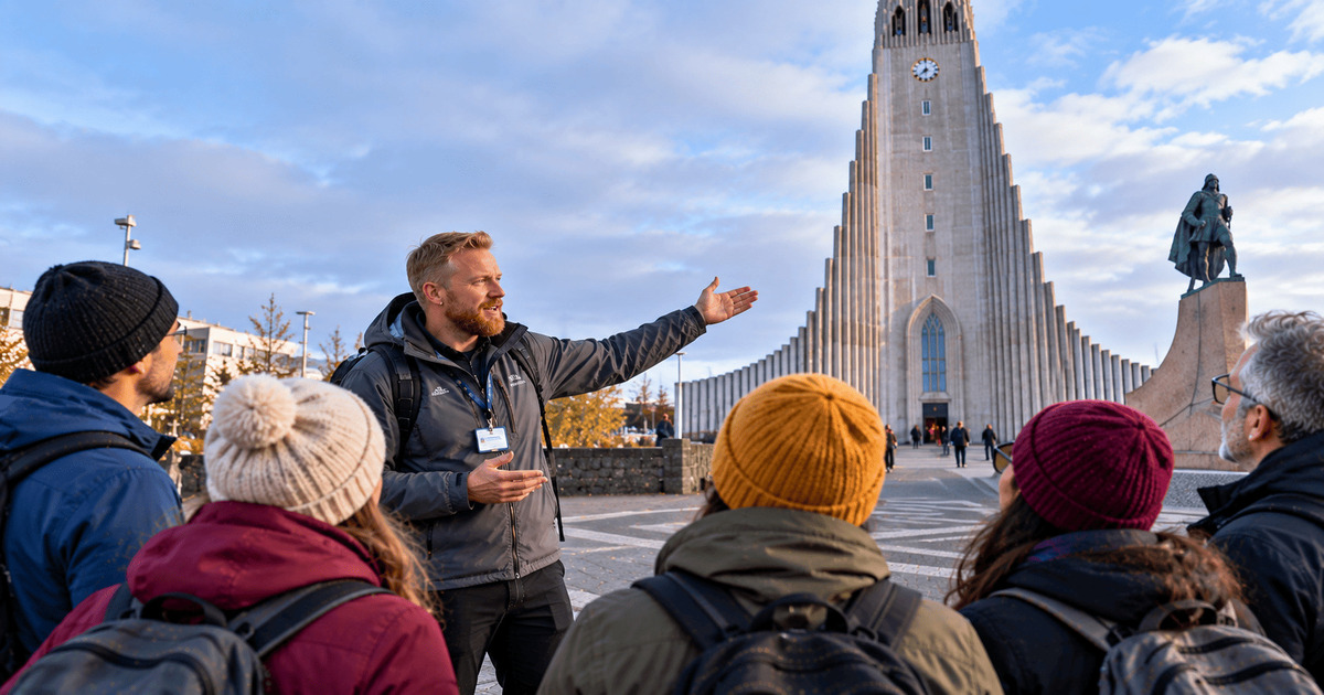 Guide touristique présentant la célèbre église Hallgrímskirkja à un groupe de voyageurs lors d'une visite guidée de Reykjavik, en Islande. Vue sur l'impressionnante architecture de l'église, sa haute tour emblématique et la statue de Leif Erikson, au cœur de la capitale islandaise.